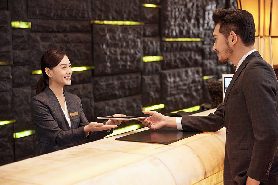 摄图网_501705235_商务男性酒店服务台办理入住(企业商用).jpg
